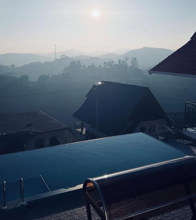 a bench sitting on top of a building with a view at Samudra Retreats Vagamon in Vagamon