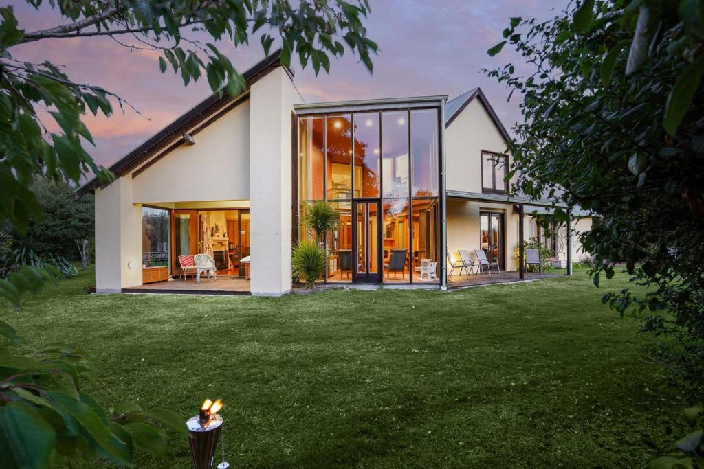 a house with large glass doors on a yard at Paradise in the city in Christchurch