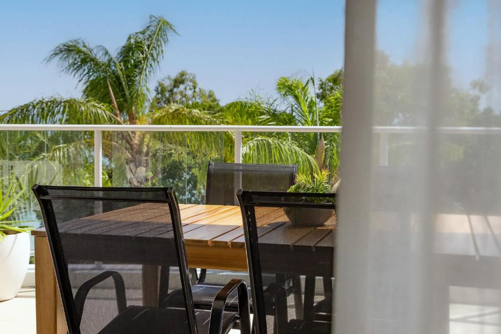 a wooden table and chairs on a balcony at Oceanview Oasis in Urangan