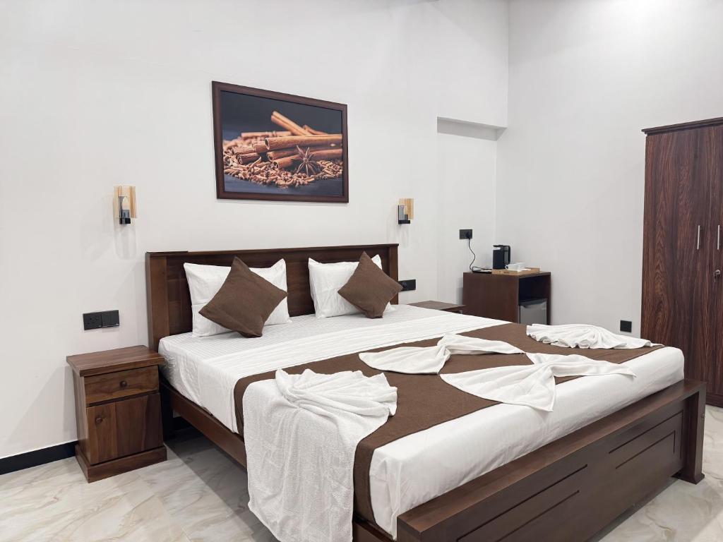 a bedroom with a large bed with white sheets at Dilaro Rest & Villa in Kottagoda