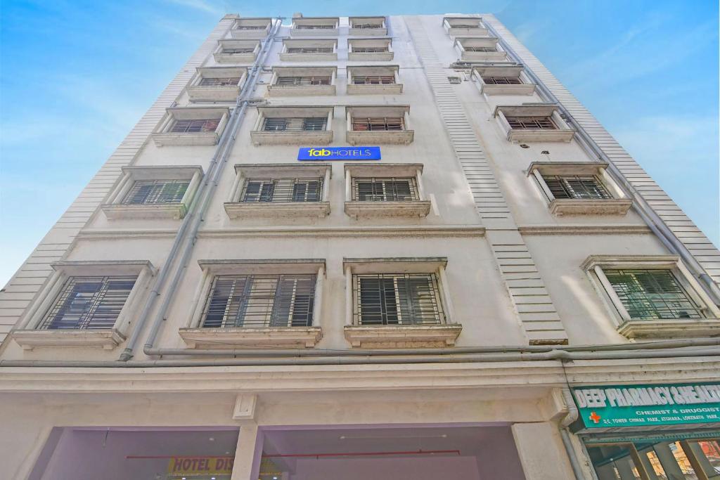 a tall building with windows and a blue sign on it at FabHotel Disa in kolkata