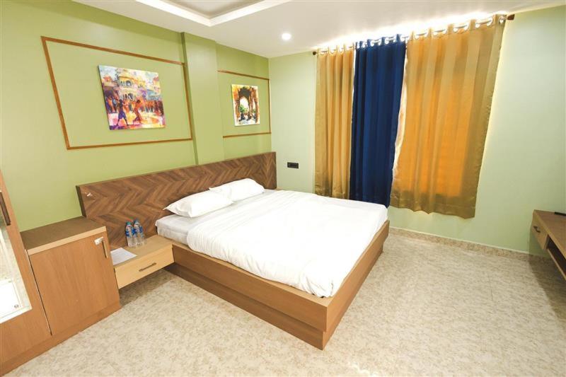 a bedroom with a large bed and a window at Lotus Leaf GuestHouse in Guwahati