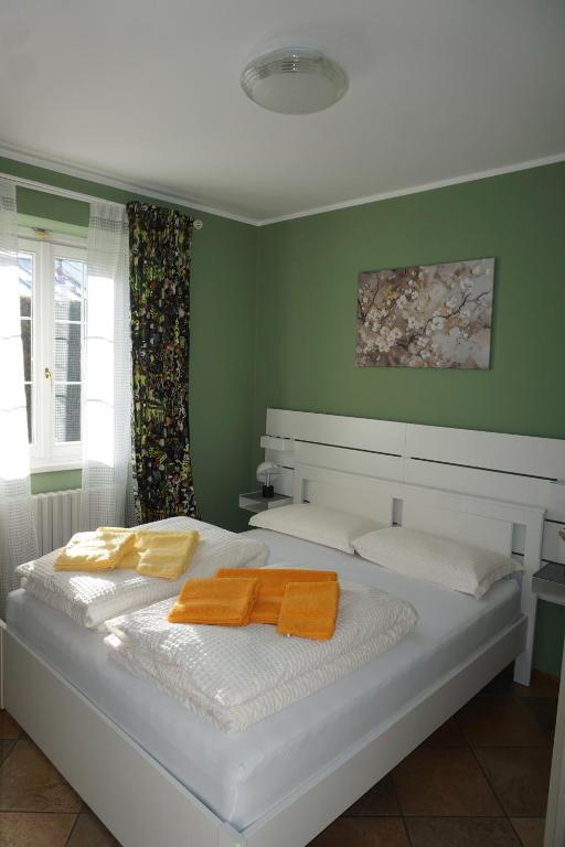 a bedroom with a large white bed with green walls at Dimora degli Gnomi in Tirano
