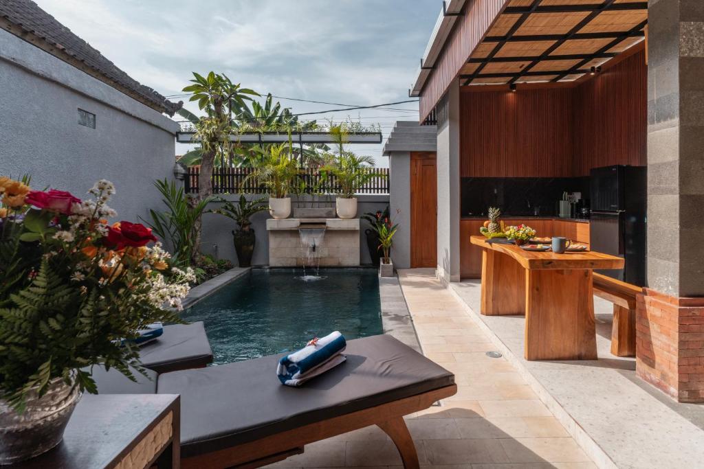a pool in the middle of a patio with a table at Villa Mesari Bona in Blahbatu