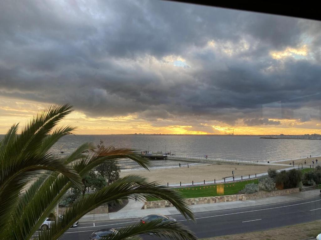 a view of the beach and the ocean at sunset at St Kilda absolute beachfront views in Melbourne