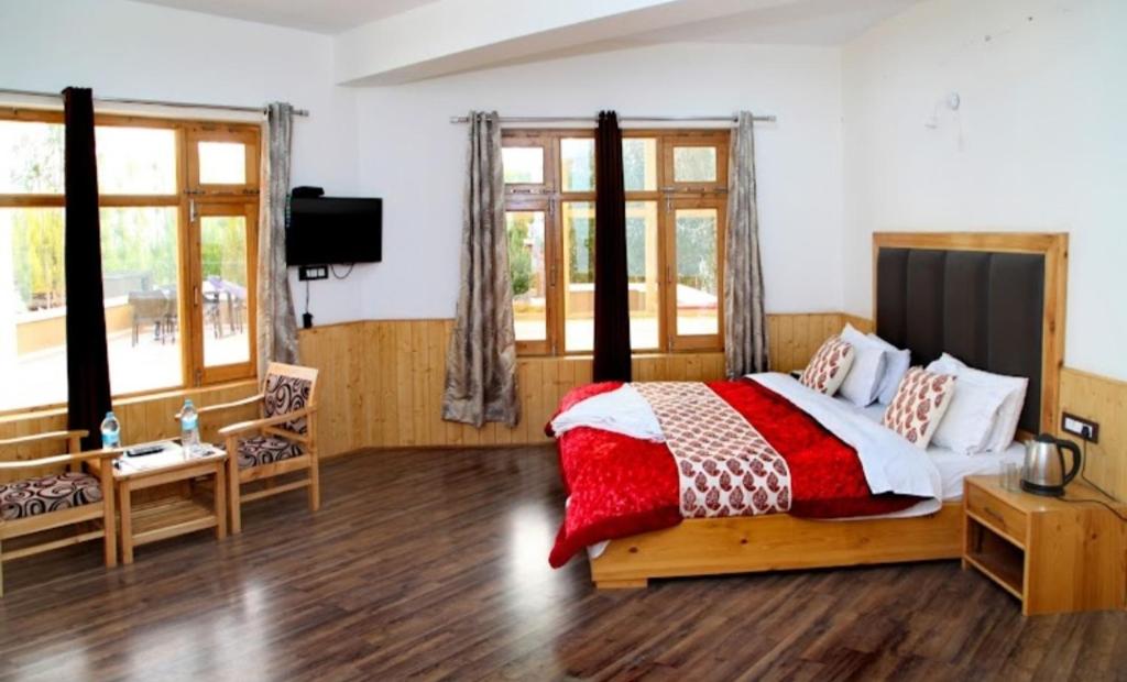 a bedroom with a bed with a red and white blanket at Glacier View Guest House in Leh