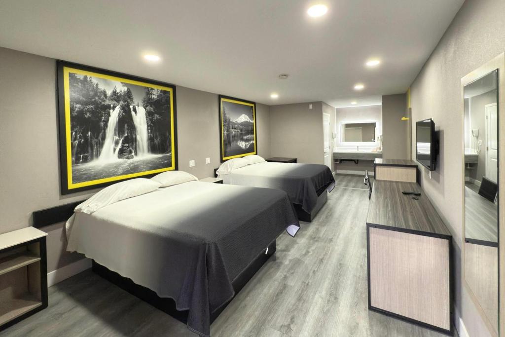 a hotel room with two beds and a tv at Super 8 by Wyndham Visalia in Visalia