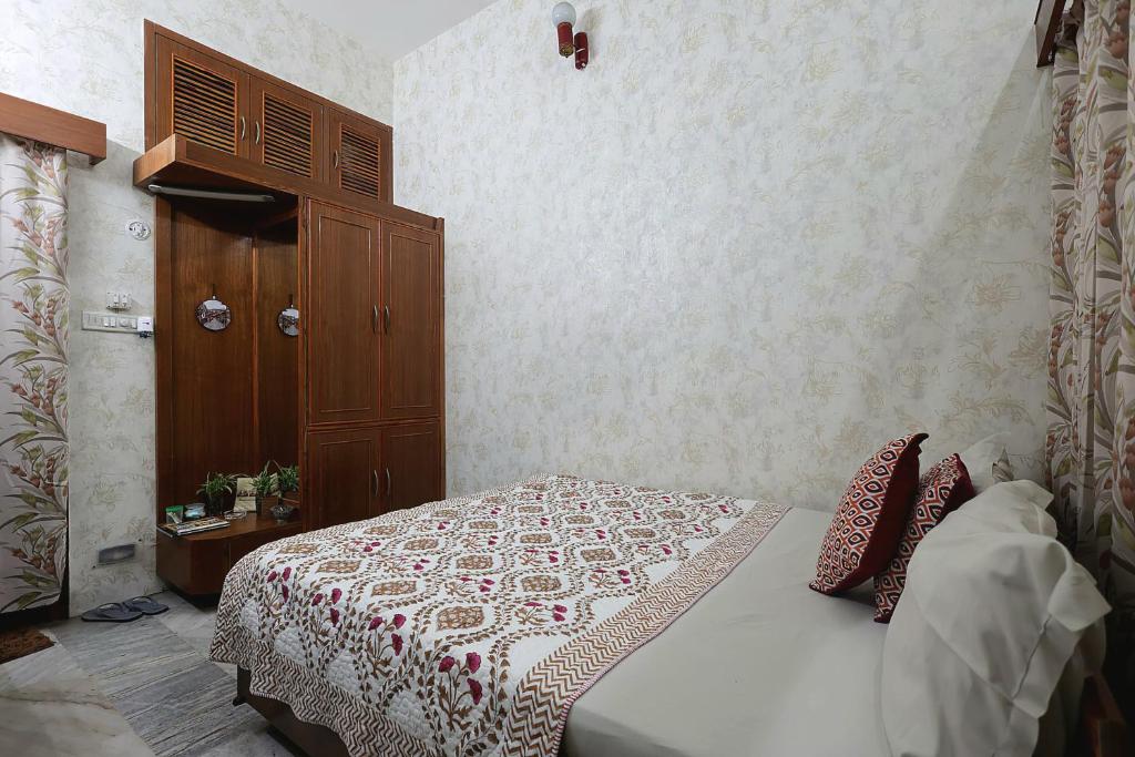 a bedroom with a bed and a wooden cabinet at Matrika Rooms in Lucknow