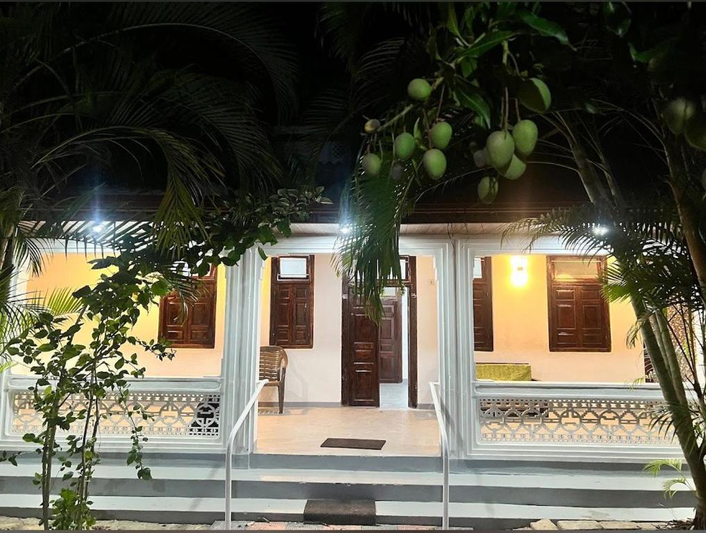 a house with palm trees in front of it at Aathi Villas in Jaffna