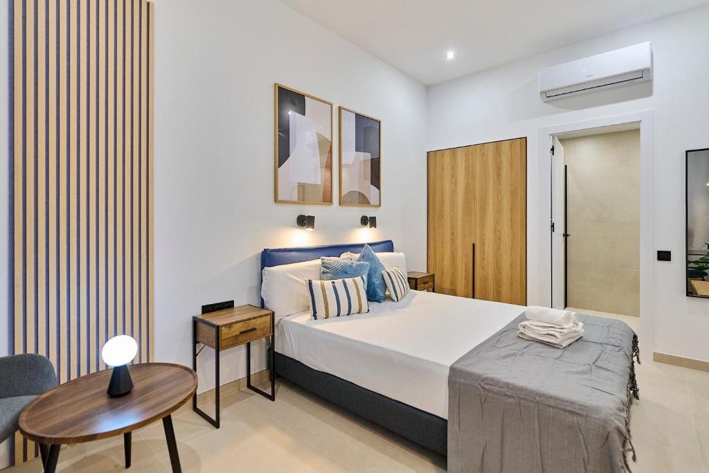 a bedroom with a large bed and a table at Sant Adrià Urban Suites by gaiarooms in Badalona