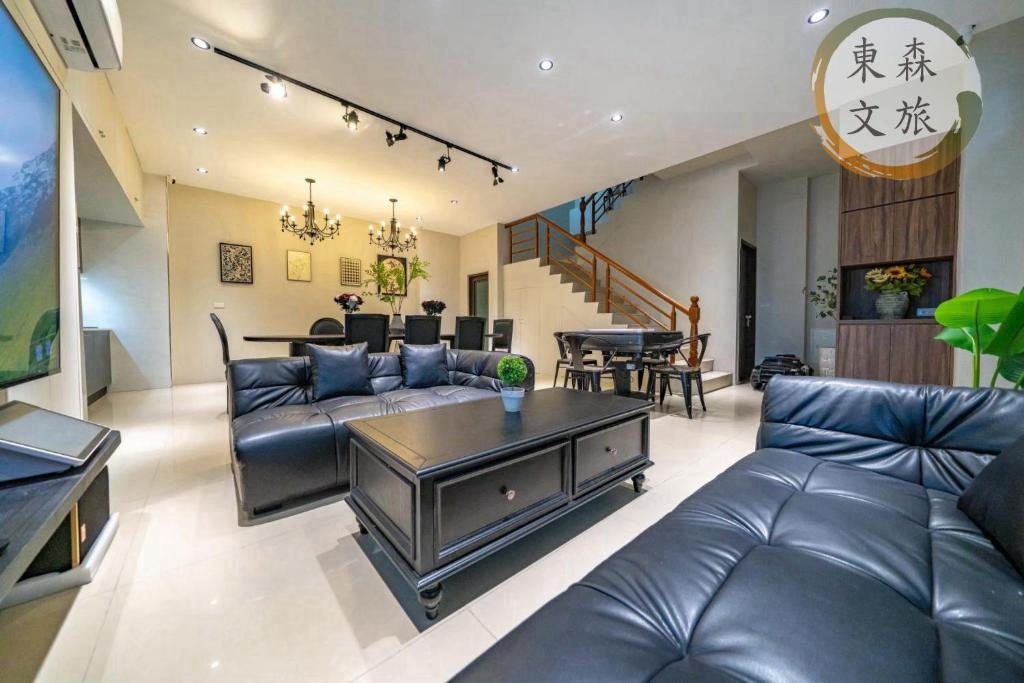 a living room with a leather couch and a table at 遇見礁溪-寵物友善-免費停車-無門禁24小時進出-東森文旅-包棟優惠中 in Jiaoxi