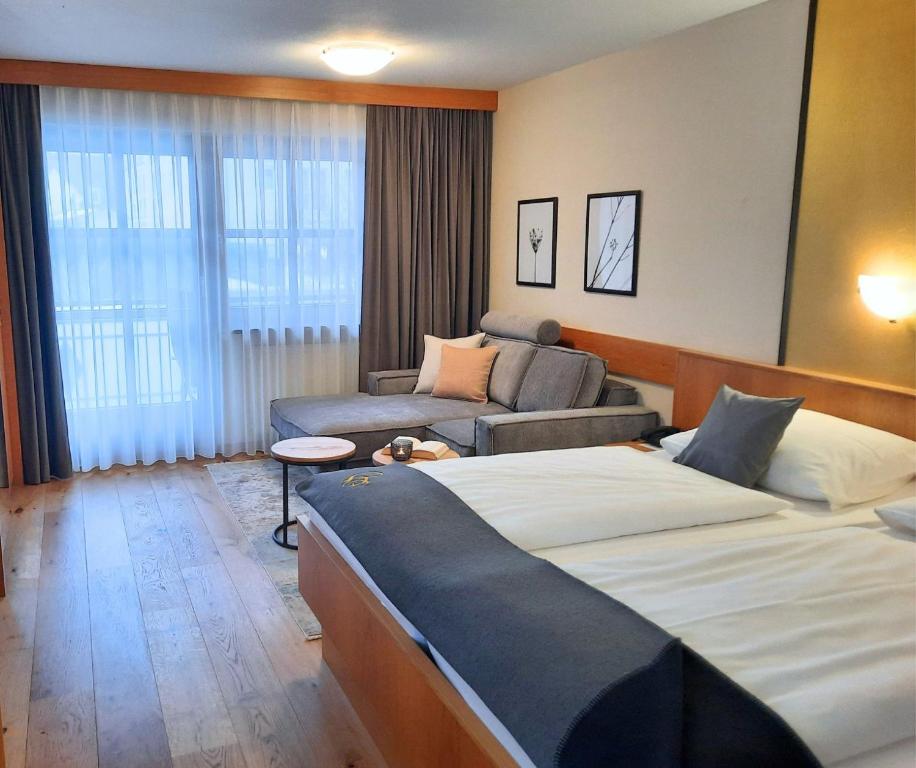 a hotel room with two beds and a couch at Appartementhaus Gaby in Bad Füssing