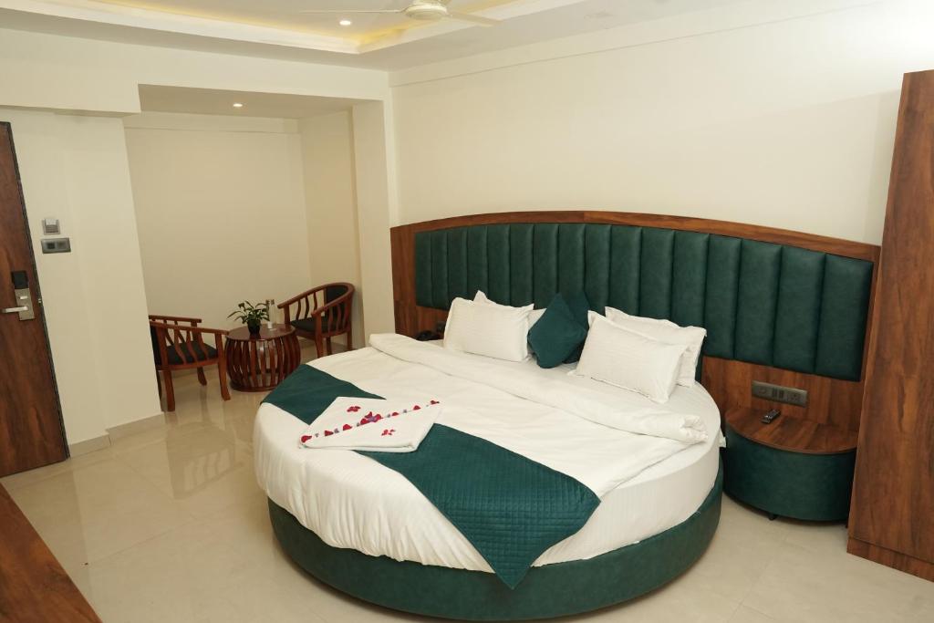 a bedroom with a large bed with a green headboard at South Forest Wayanad By Bestinn Leisure in Sultan Bathery
