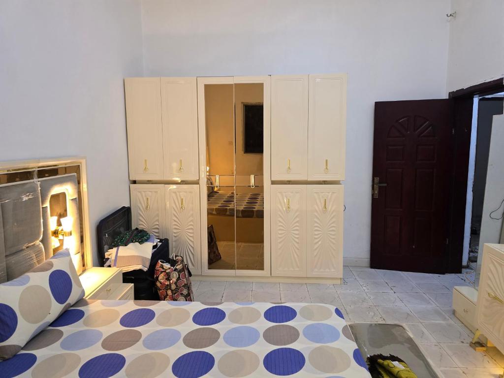 a bedroom with a bed and a large closet at Al-Ahmari Holiday Apartment in Mogadishu