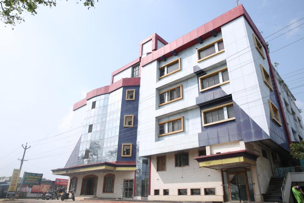 a tall white building with many windows at Sai Kirshanth Residency in Karaikal