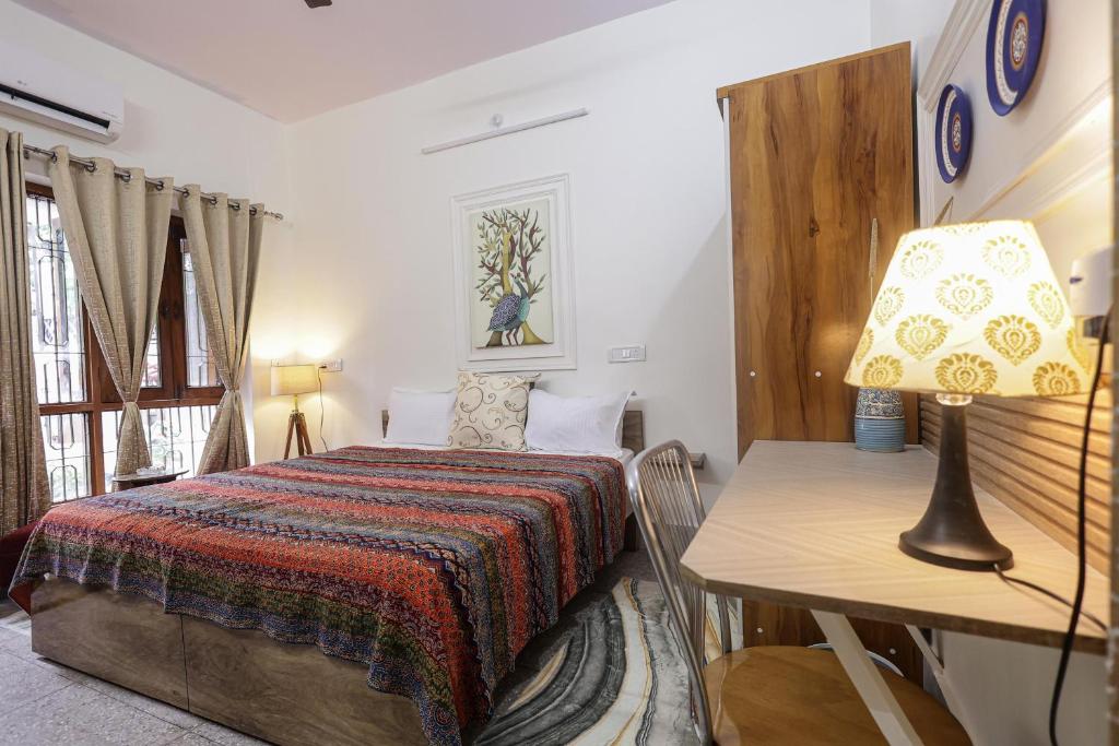 a bedroom with a bed and a table with a lamp at Matrika Stays in Lucknow