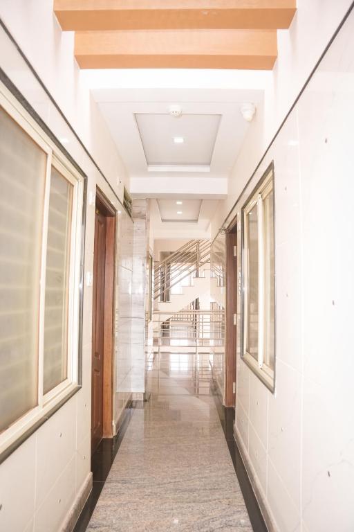 a corridor of a building with white walls and windows at Hotel Koyla Boarding and Lodging in Chikmagalūr