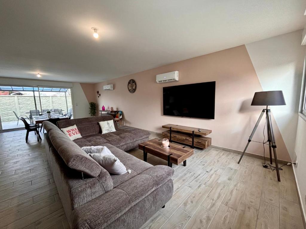 a living room with a couch and a flat screen tv at maison 24 couchages in Clermont-Créans