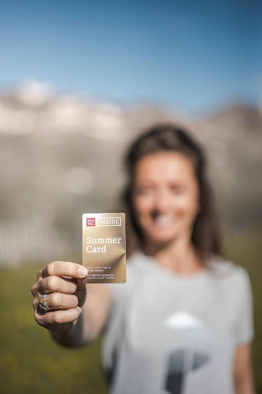 a woman is holding a card in her hand at Arche Ötztal Stuibenfall inklusive SummerCard in Umhausen