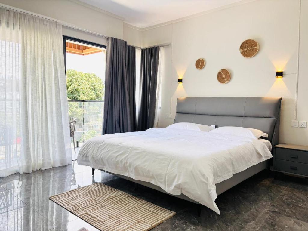 a bedroom with a large bed and a large window at West14 Tamarin Bay,Studio in Tamarin