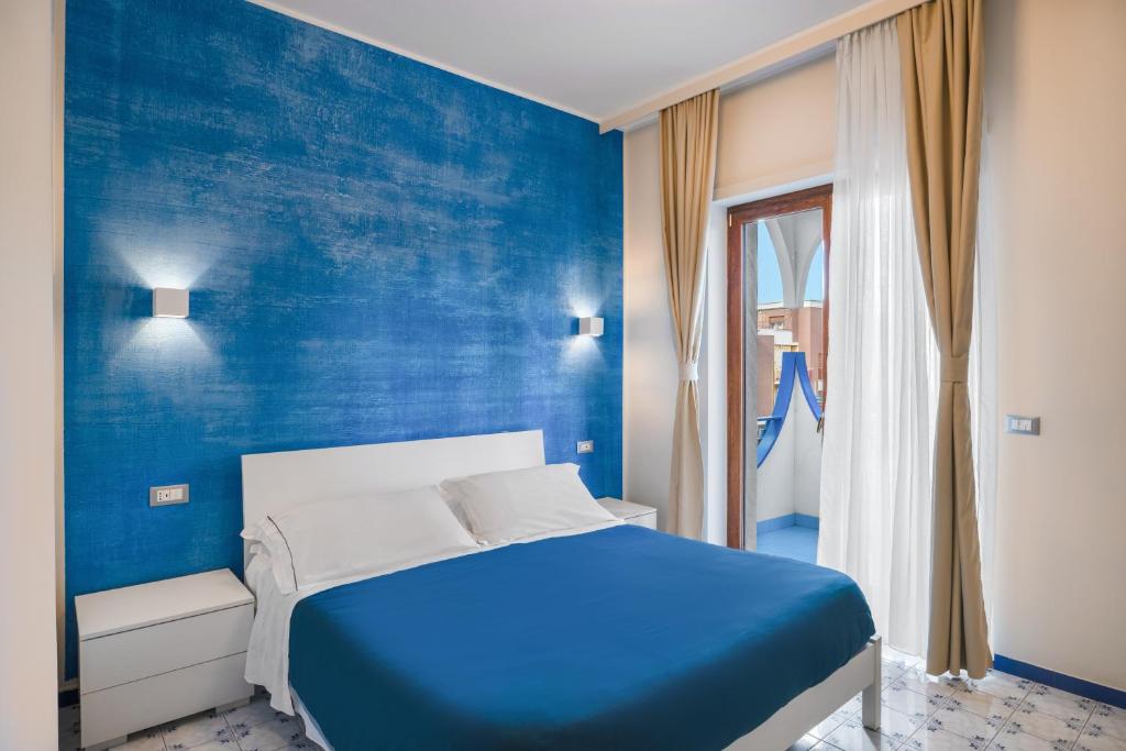 a blue bedroom with a bed and a blue wall at The Reef Sorrento in Sorrento