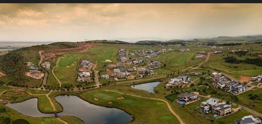an aerial view of a subdivision of houses and a lake at Eye with a view in Eikenhof