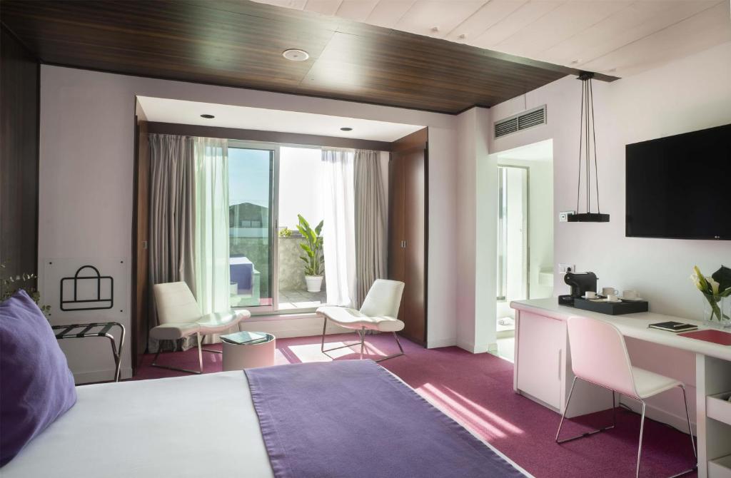 a bedroom with a bed and a desk with a computer at Allegro Barcelona in Barcelona