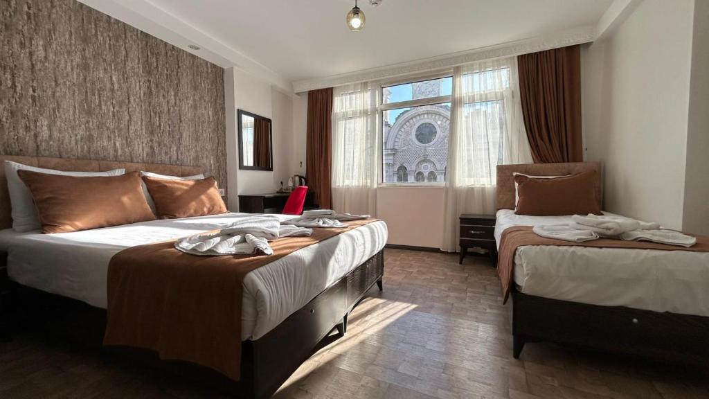 a hotel room with two beds and a window at HOTEL GLOBAL 2022 in Istanbul