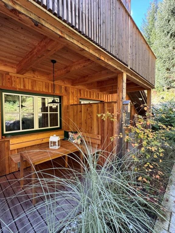 a wooden cabin with a bench in front of it at In der Hollau - Your Austrian Home in Altaussee