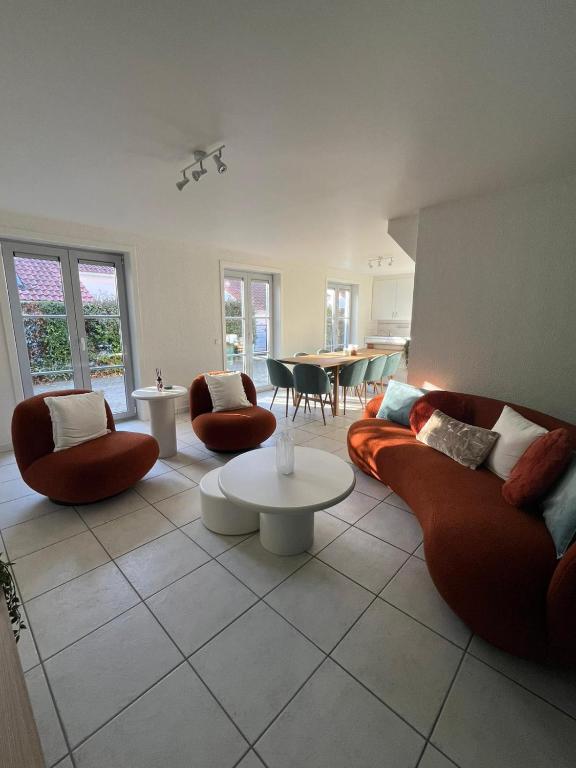 a living room with two couches and a table at Seaward Cottage met Jacuzzi in De Haan