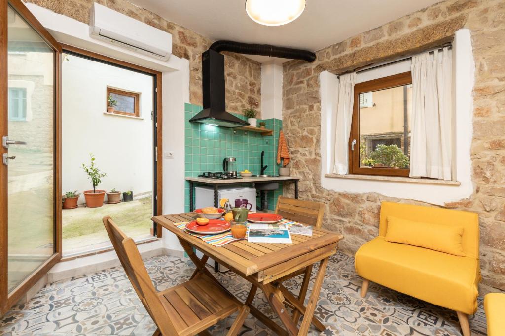a dining room with a table and a yellow chair at Climbing House in Baunei