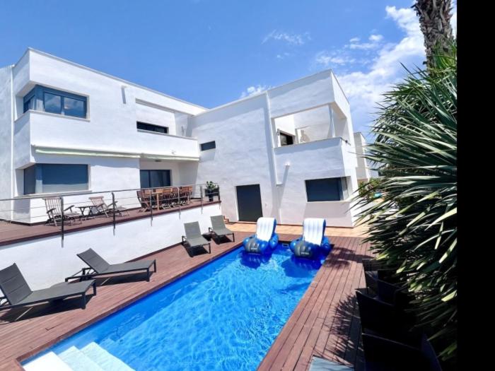 a house with a swimming pool in front of a house at R64 Deluxe Villa Déjà Vu in Calafell