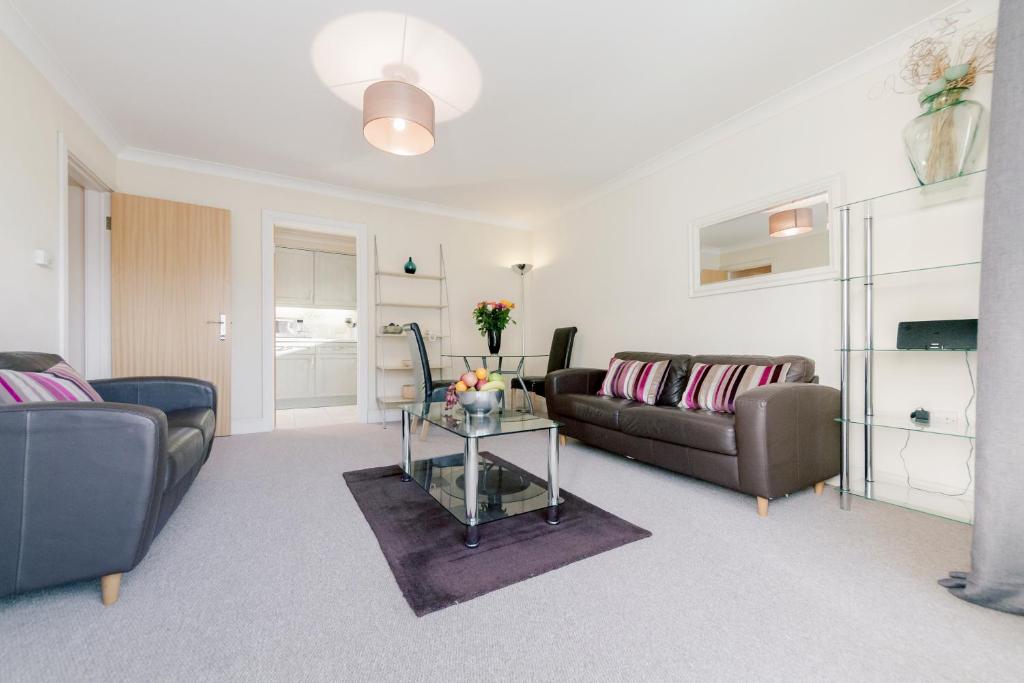 uma sala de estar com dois sofás e uma mesa em Roomspace Serviced Apartments - Cascades Court em Londres