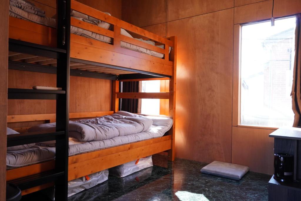 two bunk beds in a room with a window at 灯GuestHouse in Aizuwakamatsu