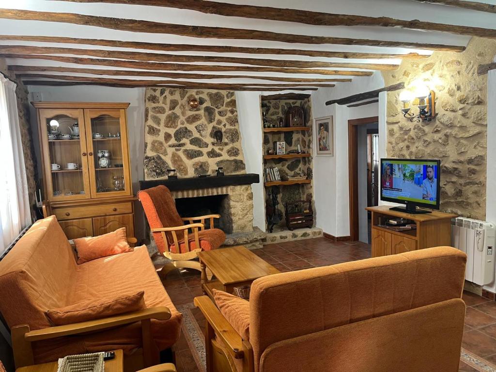 a living room with a couch and a tv at Casa Rural Vicenta in Benizar