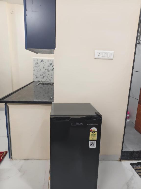 a black refrigerator in a room with a desk at Ramashraya in Indore