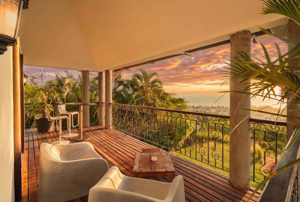 a balcony with two chairs and a view of the ocean at Sunset View by JuMa in Rivière Noire