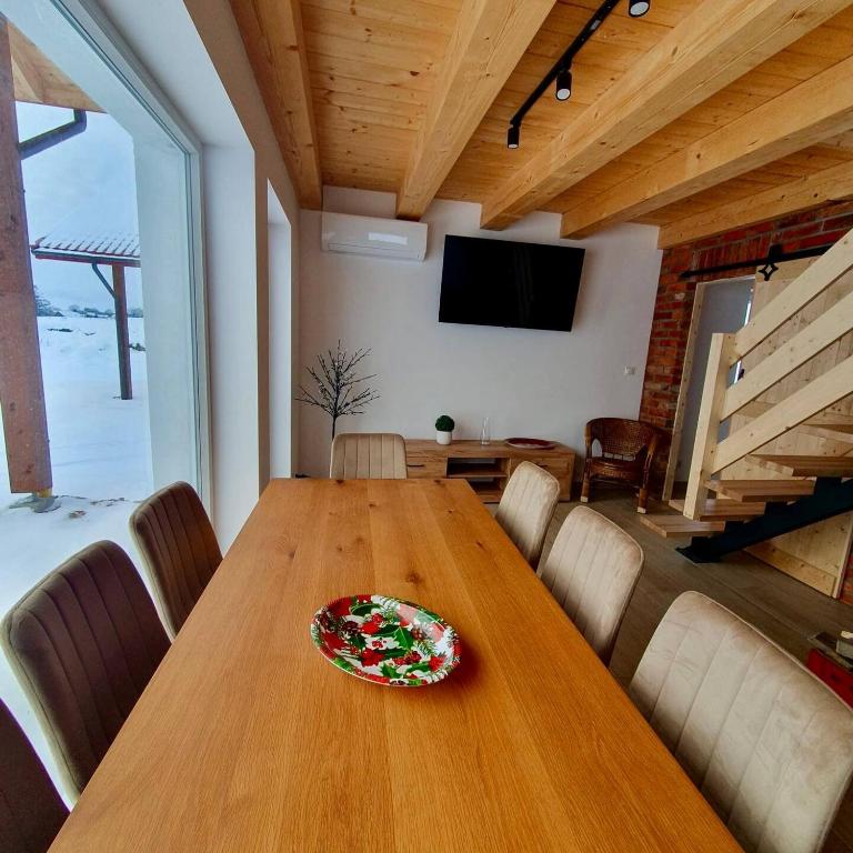 a dining room with a wooden table with a plate on it at Spokojna Dolina in Brejdyny