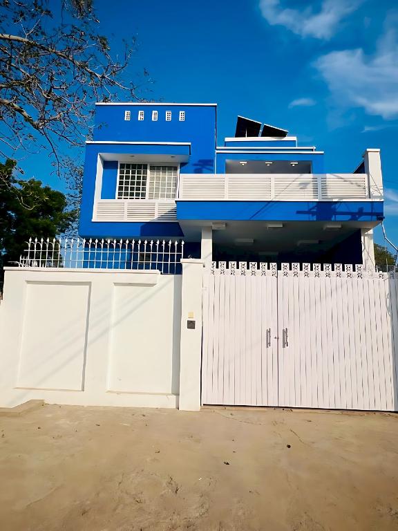 a blue house with a white fence and a gate at Hotel Marvi Multan in Multan
