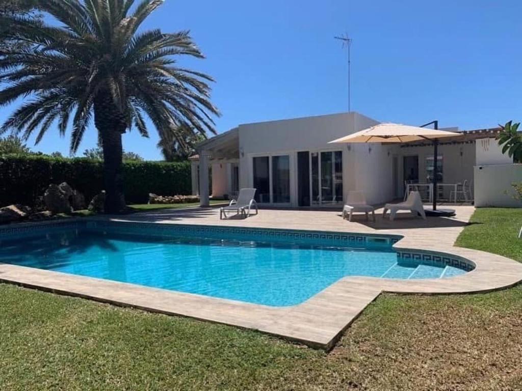 a swimming pool in front of a house at Casa SONEA private access to Cala nBrut. in Cala en Blanes