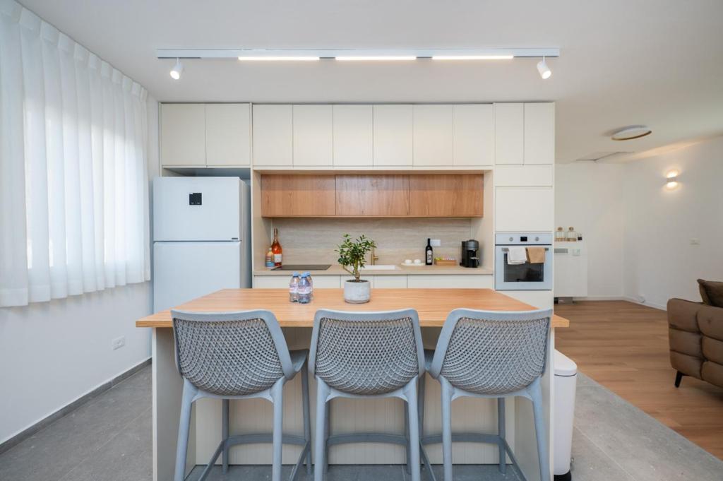 a kitchen with a wooden table and four chairs at R26-Boutique in Zikhron Ya'akov