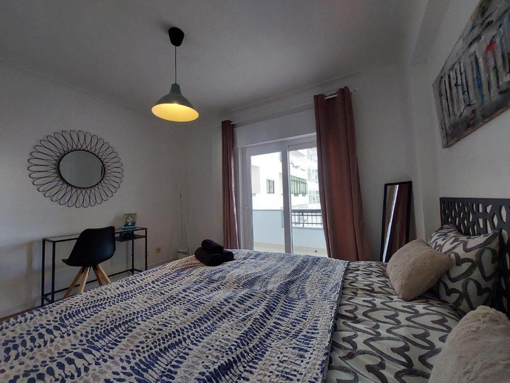 a bedroom with a bed with a cat sitting on it at Praia Dona Ana - Bedrooms in shared apartment in Lagos