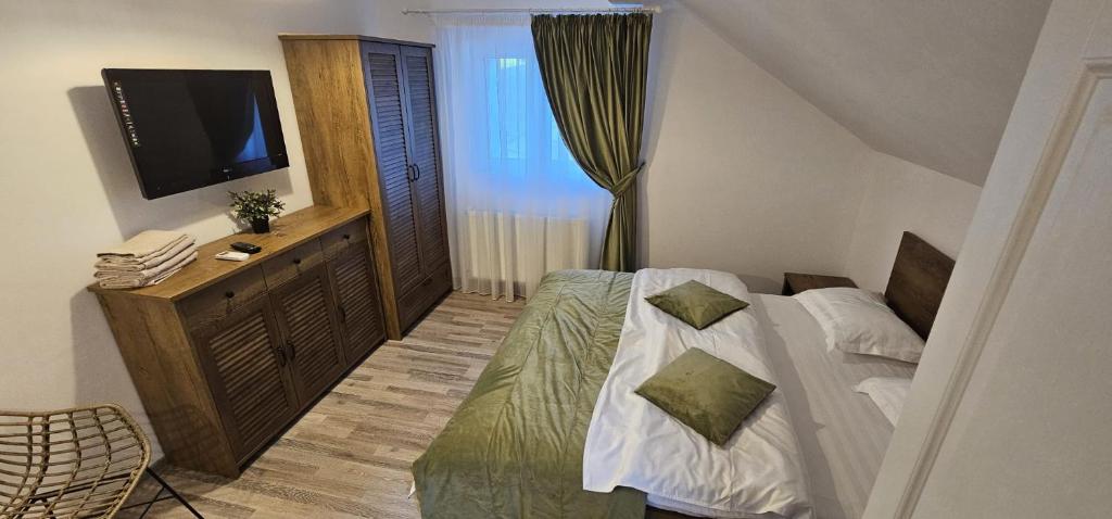 a small bedroom with a bed and a television at Forest Grill in Piatra Neamţ