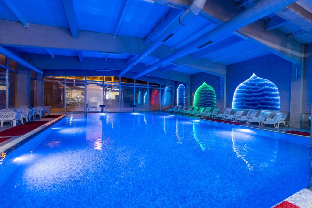 a pool in a hotel with chairs and a ball at Aqua Spa Lux in Novi Pazar