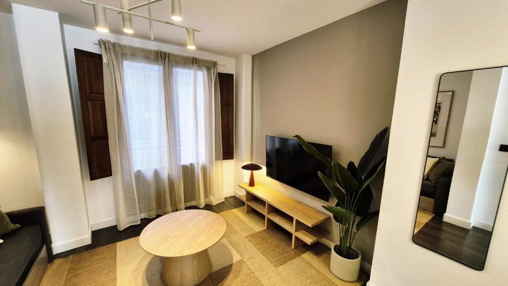 a small living room with a table and a television at Apartamentos Carmen del Turia in Valencia