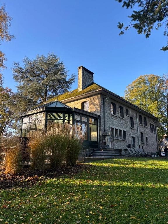 an old stone house with a glass building at Au Clos Caleste in Wellin