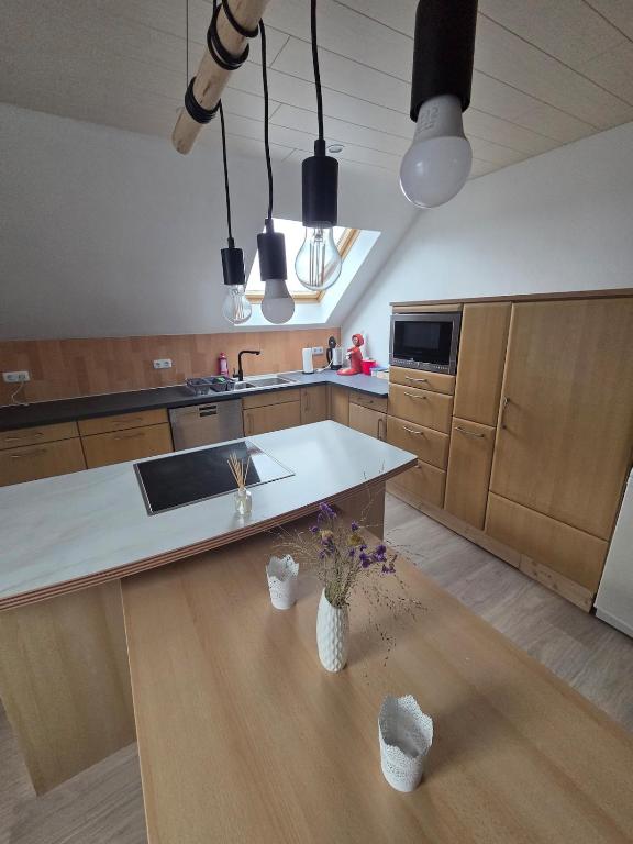 a kitchen with a white counter top and wooden cabinets at Lux-Bau - Stilvoll und modern in Schmelz