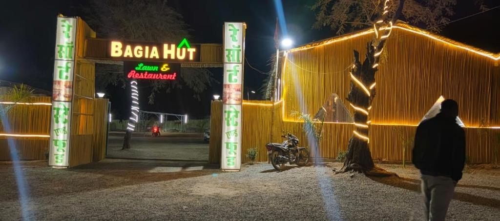 a man walking into a baja hot restaurant at night at BAGIYA Hut RESORT in Billi