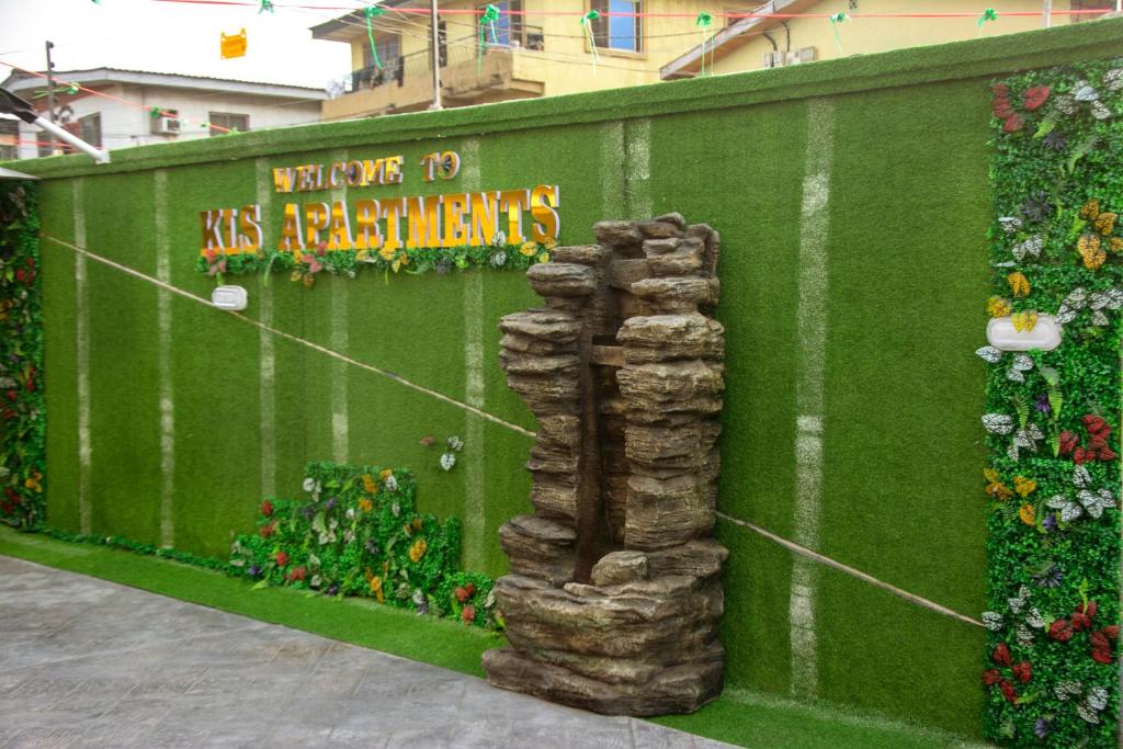 a green wall with flowers and plants on it at KLSApartment in Lagos