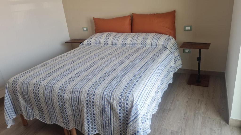 a bedroom with a bed with a blue and white comforter at Civitas Locanda in Ghedi